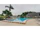 Community pool surrounded by lush landscaping and comfortable lounge chairs at 14130 Rosemary Ln # 1201, Largo, FL 33774