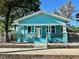 Charming turquoise home featuring a white trim, fenced yard, and inviting front porch at 1504 E 33Rd Ave, Tampa, FL 33610