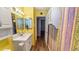 The bright bathroom has a white vanity and decorative striped wallpaper at 1515 Arrowhead Dr, Sun City Center, FL 33573