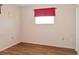 This bedroom features wood floors and a window with a red valance at 1515 Arrowhead Dr, Sun City Center, FL 33573