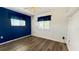 Cozy bedroom with wood floors, natural light, and a calming blue accent wall at 1515 Arrowhead Dr, Sun City Center, FL 33573