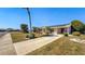 Charming single-story home featuring a well-manicured lawn, a long driveway, and solar panels on the roof at 1515 Arrowhead Dr, Sun City Center, FL 33573
