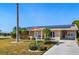 Charming home featuring a well-manicured lawn, walkway, and solar panels on the roof at 1515 Arrowhead Dr, Sun City Center, FL 33573