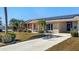 Charming home with solar panels, a well-manicured lawn, walkway, and colorful accents at 1515 Arrowhead Dr, Sun City Center, FL 33573
