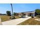 Charming single-story home featuring a well-manicured lawn, a long driveway, and solar panels on the roof at 1515 Arrowhead Dr, Sun City Center, FL 33573