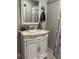 Bathroom vanity features an ornate white cabinet, neutral countertop, and decorative mirror, creating a stylish, Paris-themed atmosphere at 1516 Arrowhead Dr, Sun City Center, FL 33573