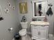 Bathroom features a toilet and vanity with ornate white cabinet, neutral countertop, and decorative mirror, creating a unique atmosphere at 1516 Arrowhead Dr, Sun City Center, FL 33573