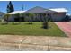 Inviting home with a well-kept lawn and young palm trees, offering a welcoming curb appeal at 1516 Arrowhead Dr, Sun City Center, FL 33573