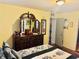 Comfortable main bedroom featuring a dark wooden dresser and four-poster bed at 1516 Arrowhead Dr, Sun City Center, FL 33573