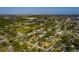 An aerial view of a residential neighborhood with green lawns, mature trees, and a baseball field under a clear blue sky at 1591 N Dakota Ne Ave, St Petersburg, FL 33703