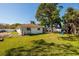View of the backyard featuring a play set, grass, partial fence, and the rear of the house at 1591 N Dakota Ne Ave, St Petersburg, FL 33703