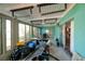 Sunroom filled with household items and renovation materials with a teal wall and ceiling at 1591 N Dakota Ne Ave, St Petersburg, FL 33703