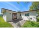 Exterior backyard view showing patio area, green grass, and the home's white facade at 1651 Summit Way, Dunedin, FL 34698
