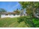 Expansive backyard with lush green lawn, mature trees, and white home exterior at 1651 Summit Way, Dunedin, FL 34698