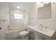 Bright bathroom featuring a shower over tub, pedestal sink, and decorative tile work at 1651 Summit Way, Dunedin, FL 34698