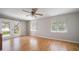 Bedroom with hardwood floors, two windows with blinds, and sliding glass doors to the backyard at 1651 Summit Way, Dunedin, FL 34698