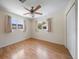 A bright bedroom with hardwood floors, two windows, and a closet at 1651 Summit Way, Dunedin, FL 34698