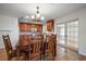 An open concept kitchen and dining area with wood cabinets, light countertops, and hardwood floors at 1651 Summit Way, Dunedin, FL 34698