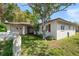 This single-story home is surrounded by mature trees, shutters, and a spacious yard at 1651 Summit Way, Dunedin, FL 34698