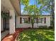 Close up of a single-story home highlighting hanging plants, shutters, and a landscaped yard at 1651 Summit Way, Dunedin, FL 34698