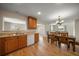 An open concept kitchen and dining area with wood cabinets, light countertops, and hardwood floors at 1651 Summit Way, Dunedin, FL 34698
