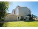 Spacious backyard with lush lawn, mature trees and privacy fence with a door to enter the home at 1806 Lago Vista Blvd, Palm Harbor, FL 34685