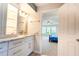 Bright bathroom with marble countertops, white cabinets, and a view into the bedroom at 1806 Lago Vista Blvd, Palm Harbor, FL 34685