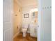 Well-lit half bathroom with a white vanity, mirror, and neutral tile flooring at 1806 Lago Vista Blvd, Palm Harbor, FL 34685
