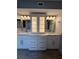 Bathroom featuring double sink vanity with granite countertop and large framed mirrors at 1806 Lago Vista Blvd, Palm Harbor, FL 34685