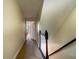 Upstairs hallway leading to a bedroom with carpet floors and wood railing at 1806 Lago Vista Blvd, Palm Harbor, FL 34685