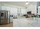 Modern kitchen featuring white cabinets, stainless steel appliances, and a marble countertop island at 1806 Lago Vista Blvd, Palm Harbor, FL 34685
