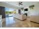 Bright living room with a fireplace, large sliding glass doors to the patio, and elegant marble floors at 1806 Lago Vista Blvd, Palm Harbor, FL 34685