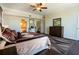 Spacious main bedroom with a ceiling fan, dark wood floors, and access to the bathroom and hallway at 1806 Lago Vista Blvd, Palm Harbor, FL 34685