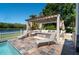 Relaxing outdoor patio features a stylish pergola, comfortable seating, and tranquil lake views for ultimate relaxation at 1806 Lago Vista Blvd, Palm Harbor, FL 34685