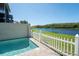 Inviting pool area with a serene view of the lake and lush greenery, enclosed by a charming white picket fence at 1806 Lago Vista Blvd, Palm Harbor, FL 34685