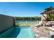 A private pool and travertine patio, with lush landscaping and a view of the water; perfect for relaxation at 1806 Lago Vista Blvd, Palm Harbor, FL 34685