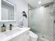 Modern bathroom with a walk-in shower with sliding glass door and vanity with backlit mirror at 19029 Us Highway 19 N # 27A, Clearwater, FL 33764