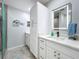 Bright bathroom with white cabinetry, quartz countertops, and a glass-enclosed shower at 19029 Us Highway 19 N # 27A, Clearwater, FL 33764