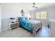 Bright bedroom with a tropical ocean-themed decor, side table, white walls, and light-colored tiled floor at 19029 Us Highway 19 N # 27A, Clearwater, FL 33764