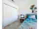 Airy bedroom with a tropical ocean-themed decor, side table, closet, white walls, and light-colored tiled floor at 19029 Us Highway 19 N # 27A, Clearwater, FL 33764