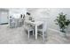 Spacious dining area with white table, bench, and view to kitchen at 19029 Us Highway 19 N # 27A, Clearwater, FL 33764