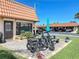 Outdoor patio area featuring a brick-paved surface, picnic table with a green umbrella, and two parked bicycles at 19029 Us Highway 19 N # 27A, Clearwater, FL 33764