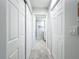 Bright hallway with white doors and tile flooring leading to the bathroom at 19029 Us Highway 19 N # 27A, Clearwater, FL 33764