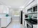 Bright kitchen featuring stainless steel appliances, white cabinets, updated backsplash, and eat in area at 19029 Us Highway 19 N # 27A, Clearwater, FL 33764