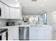 Updated kitchen with stainless steel appliances, white cabinets, eat-in counter, and open to living space at 19029 Us Highway 19 N # 27A, Clearwater, FL 33764