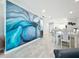 Open-concept living room showcasing a large art wall, dining area, and well-lit interior with gray flooring at 19029 Us Highway 19 N # 27A, Clearwater, FL 33764