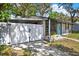 Street view of charming single-story home featuring a bright blue front door and a private fenced-in carport at 1908 E Mcberry St, Tampa, FL 33610