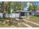 Charming single-story home featuring a bright blue door and a white fence providing privacy at 1908 E Mcberry St, Tampa, FL 33610