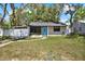 Charming single-story home with a well-manicured lawn, a bright blue front door, and a private fenced-in carport at 1908 E Mcberry St, Tampa, FL 33610