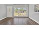 Sunlit living room showcasing large windows and beautiful hardwood flooring with a decorative front door at 1908 E Mcberry St, Tampa, FL 33610